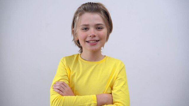 Portrait Of Smiling Handsome Teenager Boy Long Hair in Yellow T-Shirt Looking At Camera Over white Background. Positive Teen Mood. Advertising Copy Space