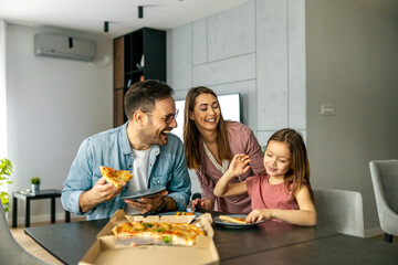 Obraz na płótnie Canvas Happy family eating pizza at home