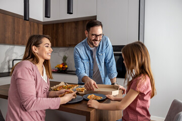 Happy family eating pizza  at home
