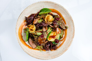Meat salad with beef slices, zucchini, cranberries, lettuce, spinach and sauce.