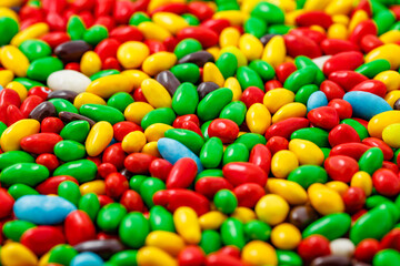 Candy in multi colored glaze in bulk, mini pieces, uniform texture pattern, wallpaper background, selective focus