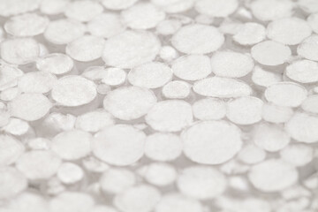 Fototapeta na wymiar Expanded polystyrene foam porous surface, small cut spheres, close-up selective focus