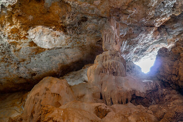  Interior of a cave, with a large pillar of stalactites and stalagmites