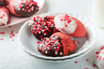 Valentines day cookies. Shortbread cookies with glaze white and dark chocolate and heart sprinkles in white plate on white background. Mothers day. Womans day. Sweet holidays baking. Top view.