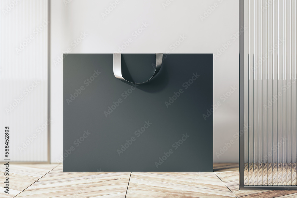 Poster front view on blank black paper shopping bag with place for your brand name or text on light wooden 
