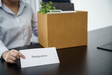 Business woman sending resignation letter to boss and Holding Stuff Resign Depress or carrying cardboard box by desk in office