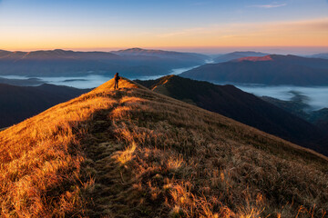 Photographer with tripod on the mountain top.