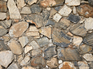 Old ancient wall with different stones as abstract background