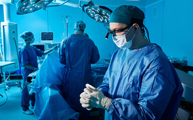Experienced surgeon psychologically prepares himself for surgical operation standing in operating...