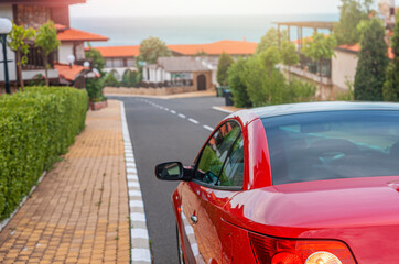 Red car on a city street a beautiful sunset.