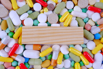 A background of many scattered multicolored tablets, capsules with space for text. Production and disposal of medicines.Pharmaceutical preparations.Sale of medicines.Vitamins for a healthy lifestyle.