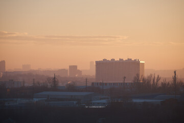 city at sunset, panorama of city, outlines of buildings, smog over industrial zone