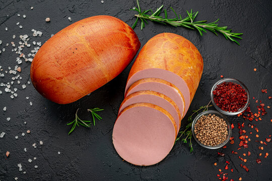 Stick of boiled sausage on a dark background.Doctor's sausage isolated on a white background.