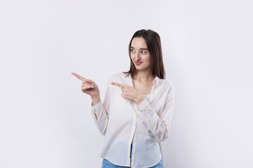 Happy young caucasian female in a shirt pointing fingers away