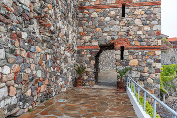 Tunnel in the stone tower. Arch in the stone building on the embankment.