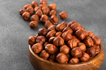 View of a bowl full of hazelnuts on a dark background
