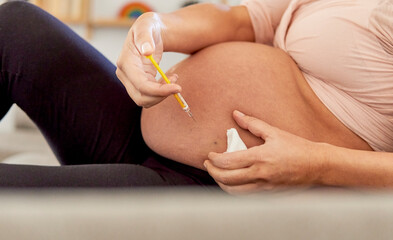 Unrecognizable pregnant woman puting injection on her belly at home. Woman injecting anticoagulant...