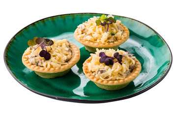 Tartlets with cheese, mushrooms, sauce and microgreens in plate isolated on white.