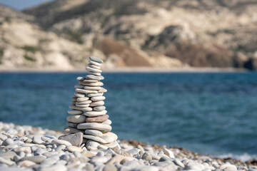 Fototapeta na wymiar Stones pyramid on background of Mediterranean sea.