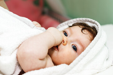 Fototapeta na wymiar Five month baby wearing towel after bath. Childhood and baby care concept