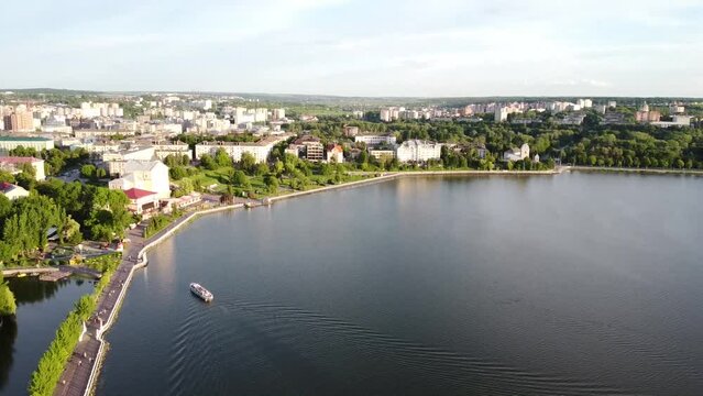 On a sunny day in Ternopil, Ukraine, a drone was used to capture an aerial view of a beautiful lake. The drone flew high above the lake, providing a stunning perspective of the surrounding area. The c