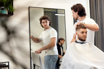 Fototapeta premium man visiting professional hairstylist in barber shop