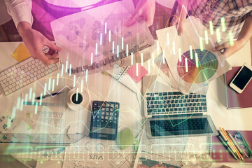 Naklejka na ściany i meble Double exposure of man and woman working together and financial chart hologram drawing. market analysis concept. Computer background. Top View.
