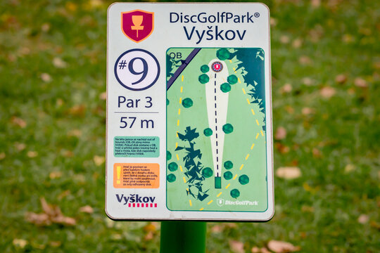 A disc golf target with basket, chains and yellow top in a park, for public sport and games in Vyskov, Czechia
