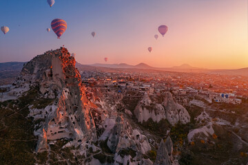 Goreme national park, Ancient Uchisar castle with colorful hot air balloons at sunset , Cappadocia Turkey