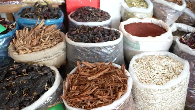 Large bags stuffed with spices and dried peppers at a local indoor farmers market in Mexico