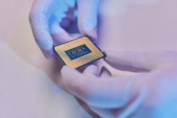 Hand in white glove holding a CPU computer processor microchip.