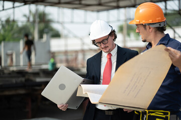 Male engineers are inspecting and controlling the work of the employees and the quality of the manufactured products to meet the standards In industrial factories producing precast prefabricated walls