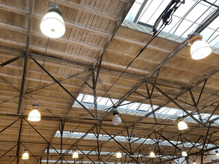 view of industrial lights hanging from the wooden roof of the hall