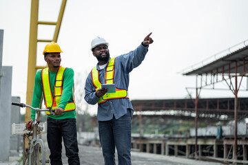 Male engineers are inspecting and controlling the work of the employees and the quality of the manufactured products to meet the standards In industrial factories producing precast prefabricated walls