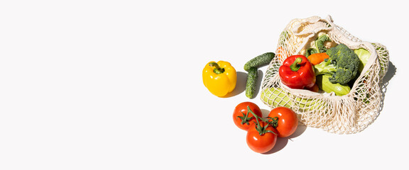 Fresh vegetables in a bag on a white background. Top view, flat lay. Banner