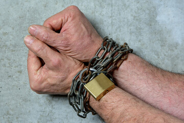 Autocracy, the end of freedom. Hands bound with steel chain.