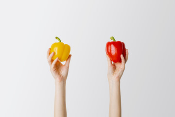 Female hands holding fresh paprika pepper on white background