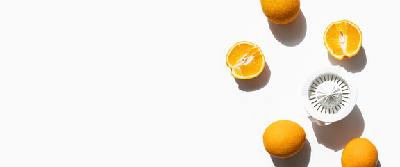 Fresh oranges prepared for juicing in a hand bowl on a white background. Top view, flat lay. Banner