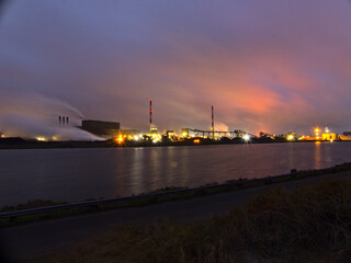 Fototapeta premium January 2023, Dunkerque - Winter walk on the Break dam - View on an industrial site 