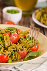 Fusilli pasta with cherry tomatoes and peas.