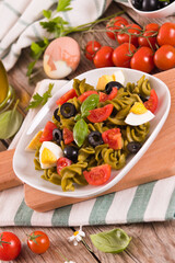 Fusilli pasta with cherry tomatoes, eggs and black olives.