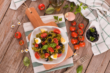 Fusilli pasta with cherry tomatoes, eggs and black olives.
