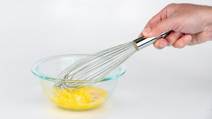 Whisk, glass bowl, and eggs being scrambled