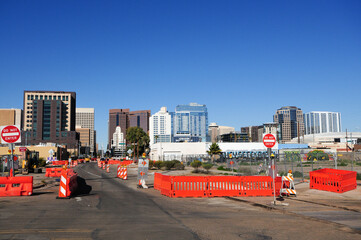 Northbound view of downtown Phoenix, Arizona skyline  from light rail extension construction zone showing do not enter traffic sign and orange barricades