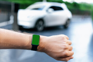 Focus mockup smartwatch with green screen for hologram or interface copyspace of electric car battery that recharging at charging station. Progressive mockup device mockup with green screen. - Powered by Adobe