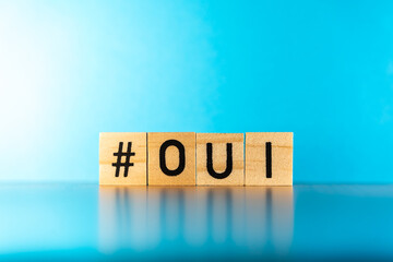 OUI word in wooden letters with blue background.  Francais concept. Franch culture. Franch concept....