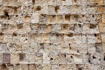 Closeup of weathered medieval stone wall with surface go to rack and ruin.