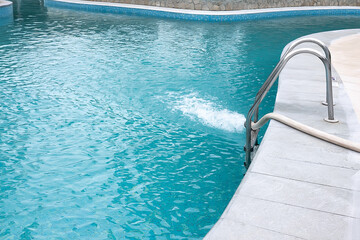 Water flowing from the hose into the pool, filling, servicing