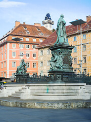 Fototapeta na wymiar Statue in the middle of the Main Square of Graz and the Uhrturm