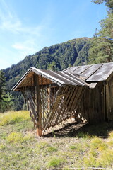 a feed rack with a small hut in the alps